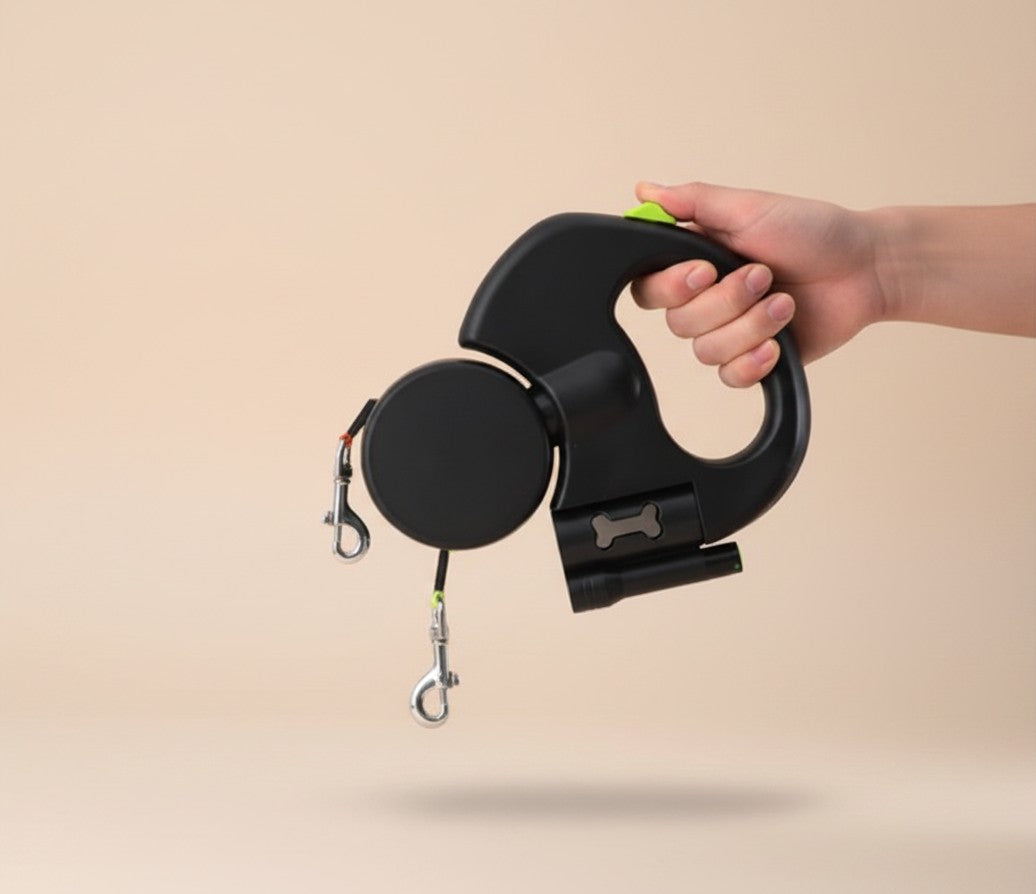 Nuzzle & Co black retractable double dog leash with built-in LED light and comfort grip handle held in a hand